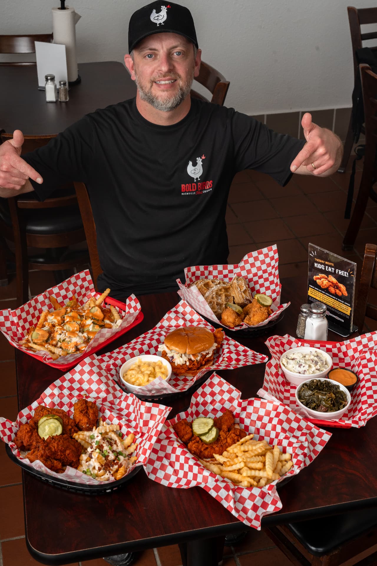 Bold Birds owner with a full spread of Nashville hot chicken tenders, sandwiches, loaded fries and Southern sides